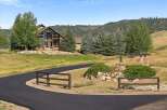 Discover this stunning mountain home featuring a grand stone facade and expansive windows that capture breathtaking views.