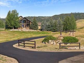 Discover this stunning mountain home featuring a grand stone facade and expansive windows that capture breathtaking views.