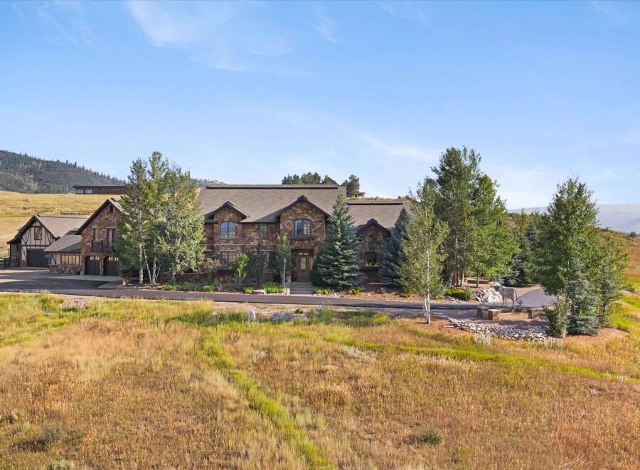 Experience luxury mountain living in this stunning stone estate, nestled amidst rolling hills and mature trees.