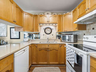 This charming kitchen boasts beautiful wooden cabinetry and a functional layout, perfect for culinary enthusiasts.