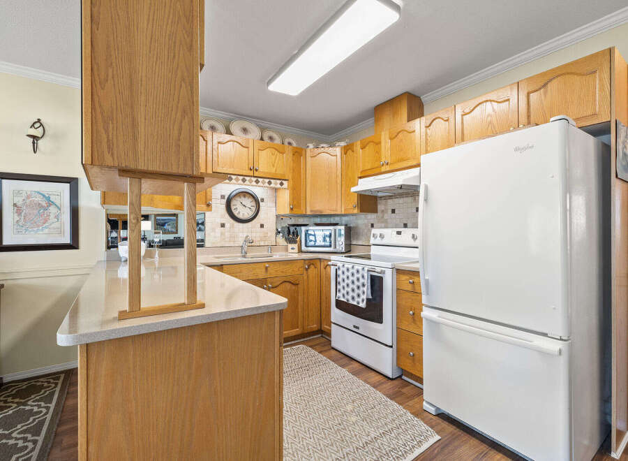 Step into this inviting kitchen, featuring warm wooden cabinetry and ample counter space.