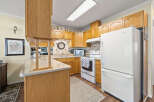 Step into this inviting kitchen, featuring warm wooden cabinetry and ample counter space.