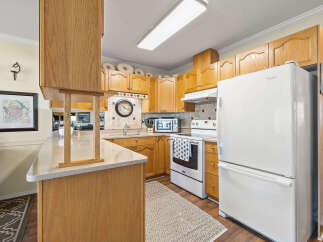 Step into this inviting kitchen, featuring warm wooden cabinetry and ample counter space.