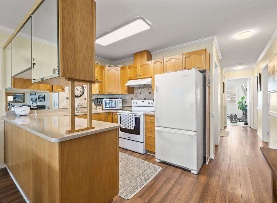 Step into this inviting kitchen, featuring warm wood cabinetry and a functional layout.