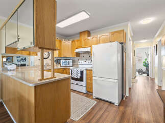 Step into this inviting kitchen, featuring warm wood cabinetry and a functional layout.