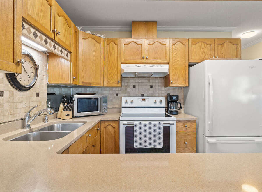 This charming kitchen boasts warm wooden cabinetry, offering ample storage and a classic aesthetic.