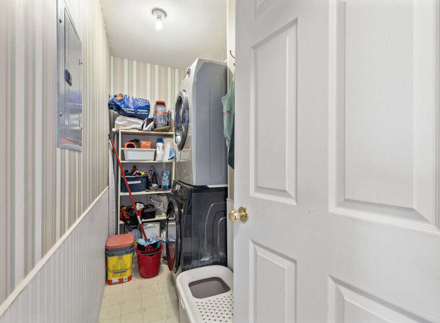 Discover the convenience of this well-organized laundry room! Featuring a stacked washer and dryer, this space maximizes functionality.