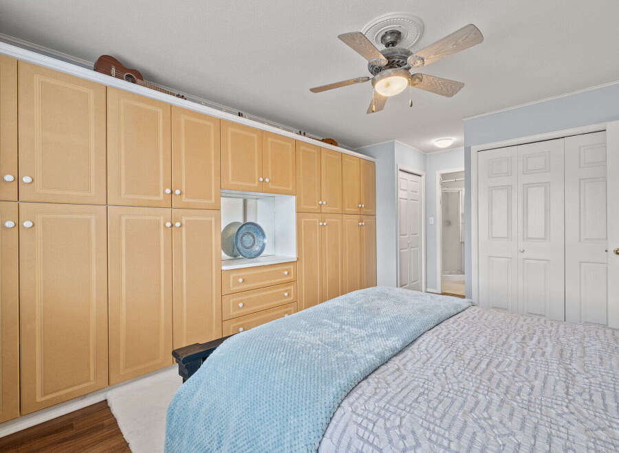 This bedroom boasts ample storage with custom built-in cabinetry, perfect for keeping your space organized.
