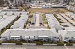 Discover a charming residential complex featuring well-maintained townhouses with gray roofs and white exteriors.