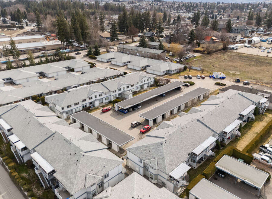 Discover a charming residential complex featuring well-maintained townhouses with ample parking and covered carports.