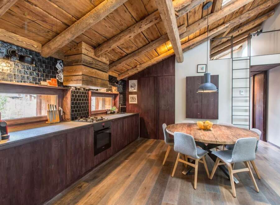 This stunning kitchen boasts a rustic charm with its exposed wooden beams and rich, dark cabinetry.