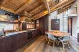 This stunning kitchen boasts a rustic charm with its exposed wooden beams and rich, dark cabinetry.