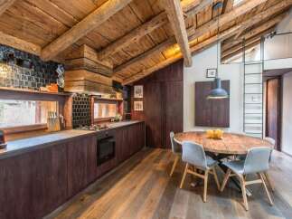 This stunning kitchen boasts a rustic charm with its exposed wooden beams and rich, dark cabinetry.