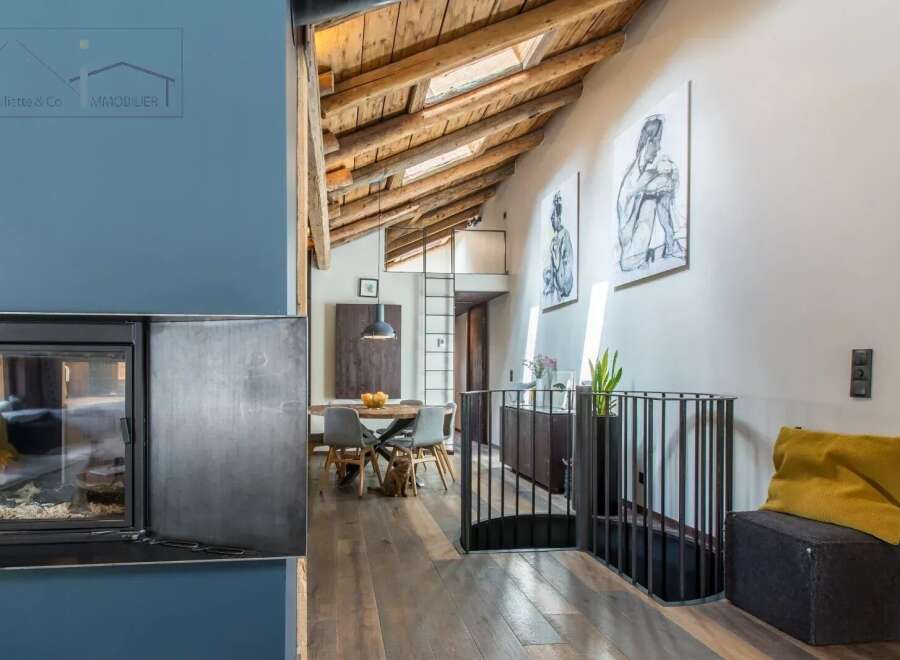 Discover the charm of this stunning property, featuring a unique architectural design with exposed wooden beams and a cozy fireplace.
