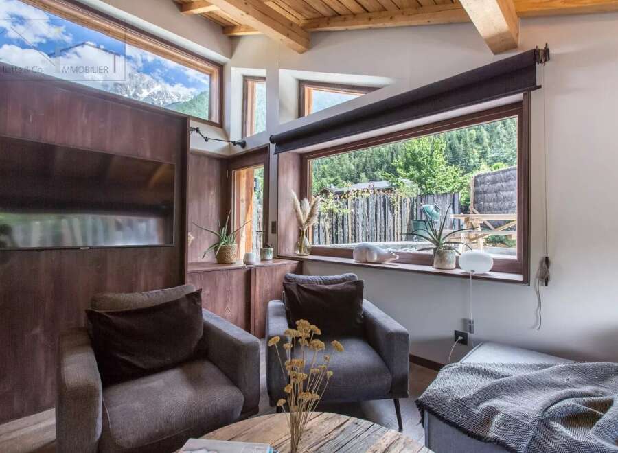 Discover the charm of this cozy living space, featuring stunning mountain views framed by large windows.