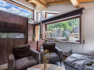 Discover the charm of this cozy living space, featuring stunning mountain views framed by large windows.