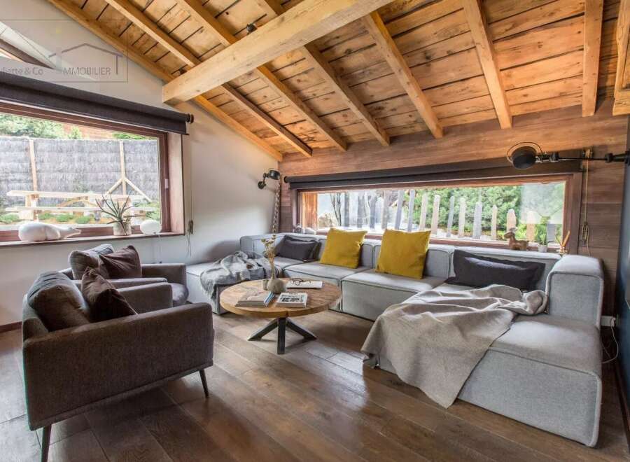 This stunning living room boasts a rustic charm with its wooden ceiling and flooring, creating a warm and inviting atmosphere.