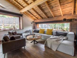 This stunning living room boasts a rustic charm with its wooden ceiling and flooring, creating a warm and inviting atmosphere.