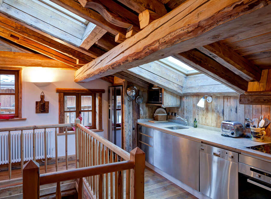 Experience rustic charm in this stunning property featuring exposed wooden beams and a cozy kitchen.