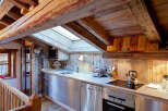 This charming kitchen boasts a rustic design with exposed wooden beams and paneling, creating a warm and inviting atmosphere.
