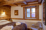 Experience rustic charm in this cozy bedroom featuring exposed wooden beams and a warm, inviting atmosphere.