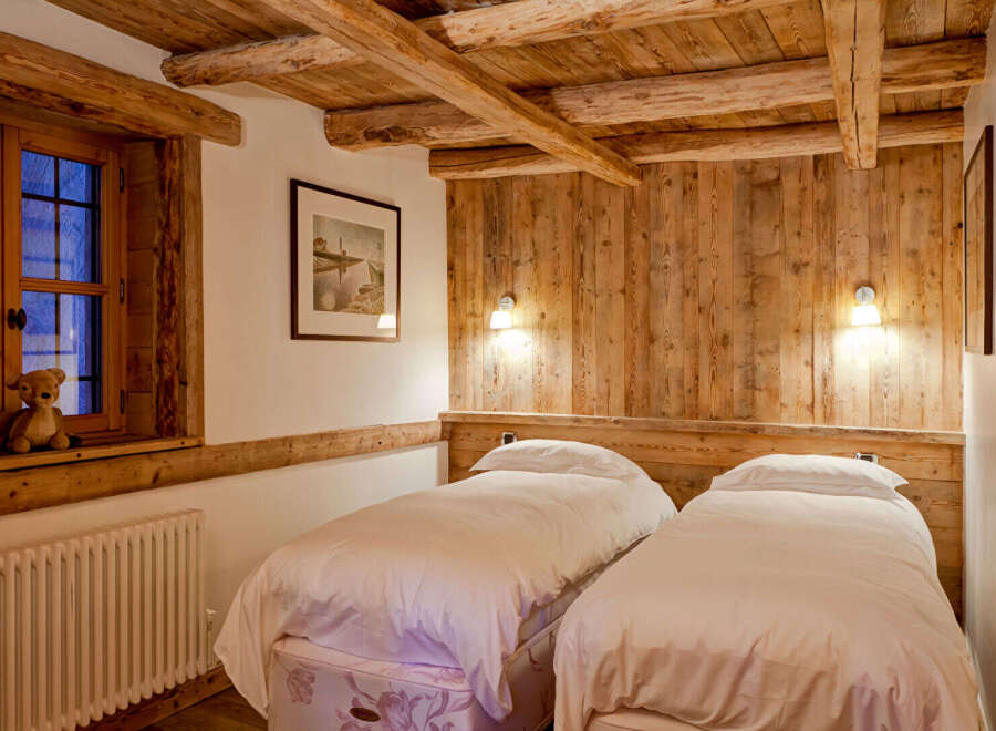 This cozy bedroom features rustic wooden beams and paneling, creating a warm and inviting atmosphere.