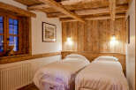 This cozy bedroom features rustic wooden beams and paneling, creating a warm and inviting atmosphere.