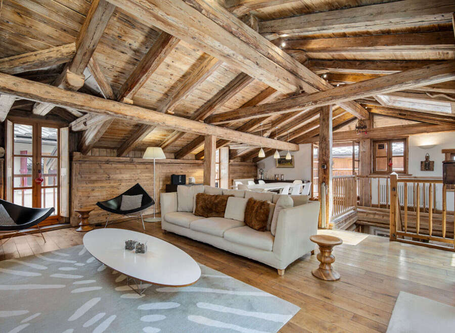 Experience rustic charm in this stunning mountain chalet featuring exposed wooden beams and a cozy living area.