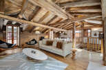 Experience rustic charm in this stunning mountain chalet featuring exposed wooden beams and a cozy living area.