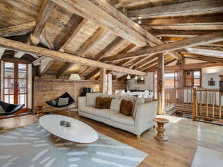 Experience rustic charm in this stunning mountain chalet featuring exposed wooden beams and a cozy living area.