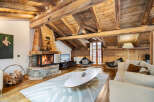 Experience rustic luxury in this stunning living room, featuring a magnificent stone fireplace and exposed wooden beams that create a warm, inviting ambiance.