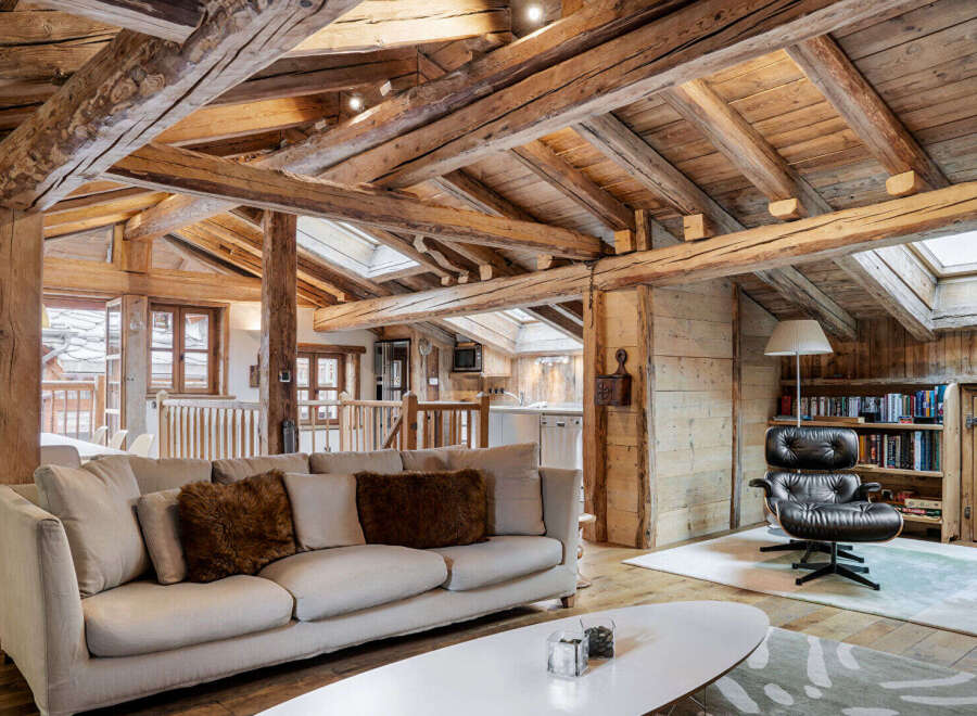 Experience rustic luxury in this charming mountain retreat, featuring exposed wooden beams and a cozy living area.