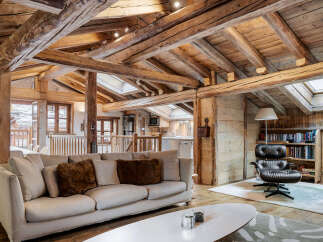 Experience rustic luxury in this charming mountain retreat, featuring exposed wooden beams and a cozy living area.