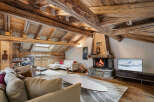 Experience rustic luxury in this stunning living room, featuring exposed wooden beams and a magnificent stone fireplace.