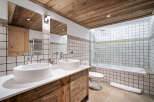 Experience rustic charm in this mountain-inspired bathroom, featuring a double vanity with vessel sinks and warm wooden cabinetry.
