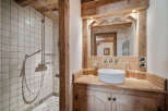 Experience rustic charm in this bathroom featuring a spacious walk-in shower with classic tiled walls and a modern rainfall showerhead.