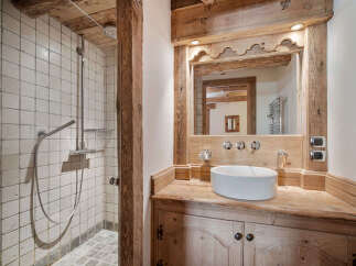 Experience rustic charm in this bathroom featuring a spacious walk-in shower with classic tiled walls and a modern rainfall showerhead.