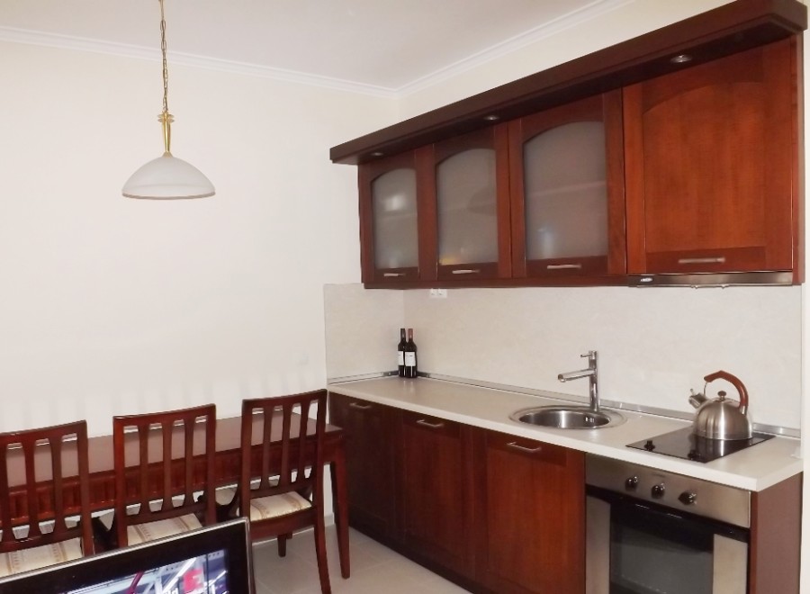 This cozy kitchen features dark wood cabinetry, a built-in oven, and a sleek countertop.