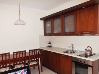 This cozy kitchen features dark wood cabinetry, a built-in oven, and a sleek countertop.