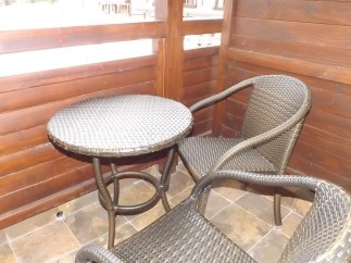 Enjoy your morning coffee on this charming balcony, complete with a cozy wicker table and chairs.