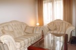 Relax in style in this elegant living room, featuring a plush sofa and armchair, perfect for unwinding after a long day.