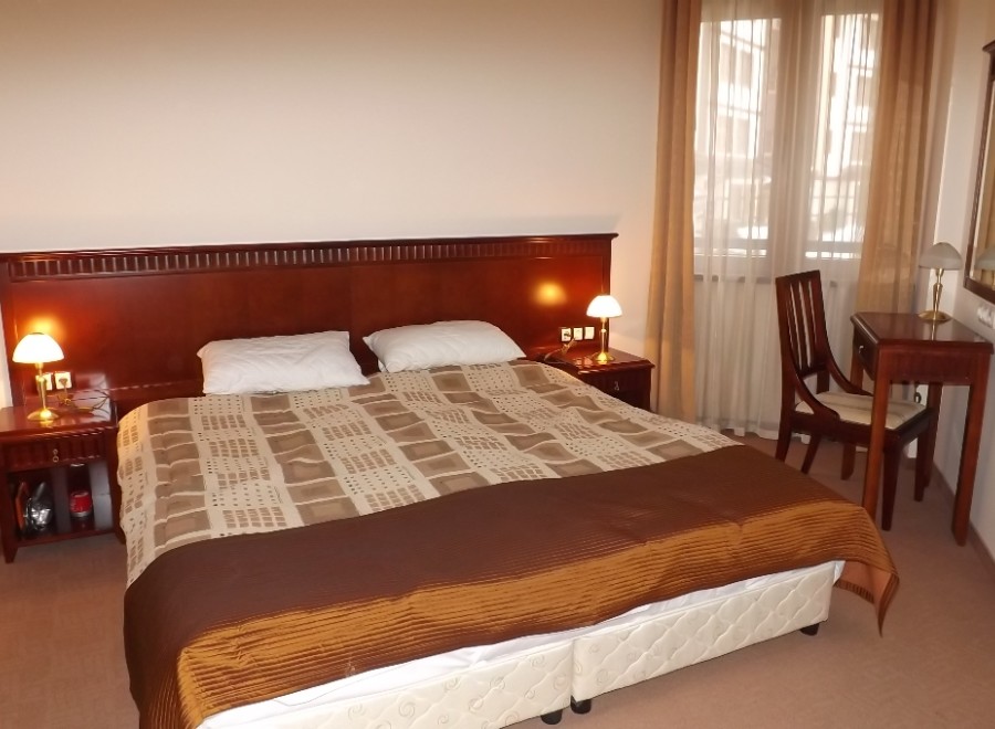 Relax in our comfortable hotel room, featuring a large double bed with a luxurious comforter and plush pillows.