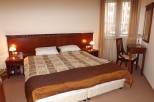 Relax in our comfortable hotel room, featuring a large double bed with a luxurious comforter and plush pillows.