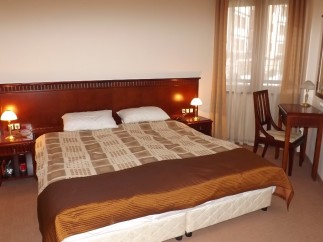 Relax in our comfortable hotel room, featuring a large double bed with a luxurious comforter and plush pillows.