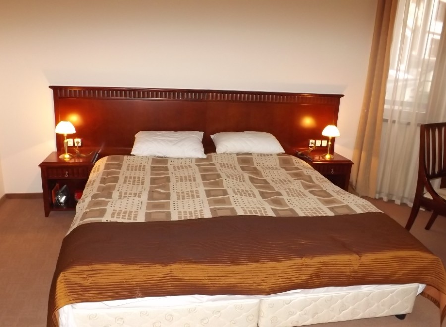 Relax in our comfortable hotel room, featuring a plush king-size bed with a luxurious comforter and crisp linens.