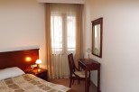Relax in this cozy hotel room featuring a comfortable bed, a convenient work desk, and a large mirror.