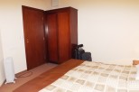 Cozy bedroom with a double bed, wooden wardrobe, and ensuite bathroom.
