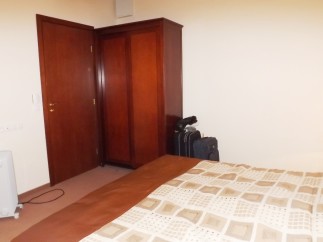 Cozy bedroom with a double bed, wooden wardrobe, and ensuite bathroom.