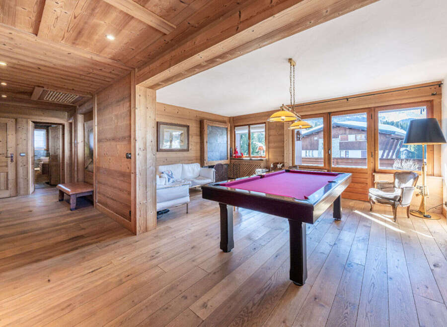 Experience luxury mountain living in this stunning chalet, featuring a dedicated games room with a vibrant pool table perfect for evening entertainment.