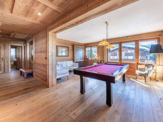 Experience luxury mountain living in this stunning chalet, featuring a dedicated games room with a vibrant pool table perfect for evening entertainment.